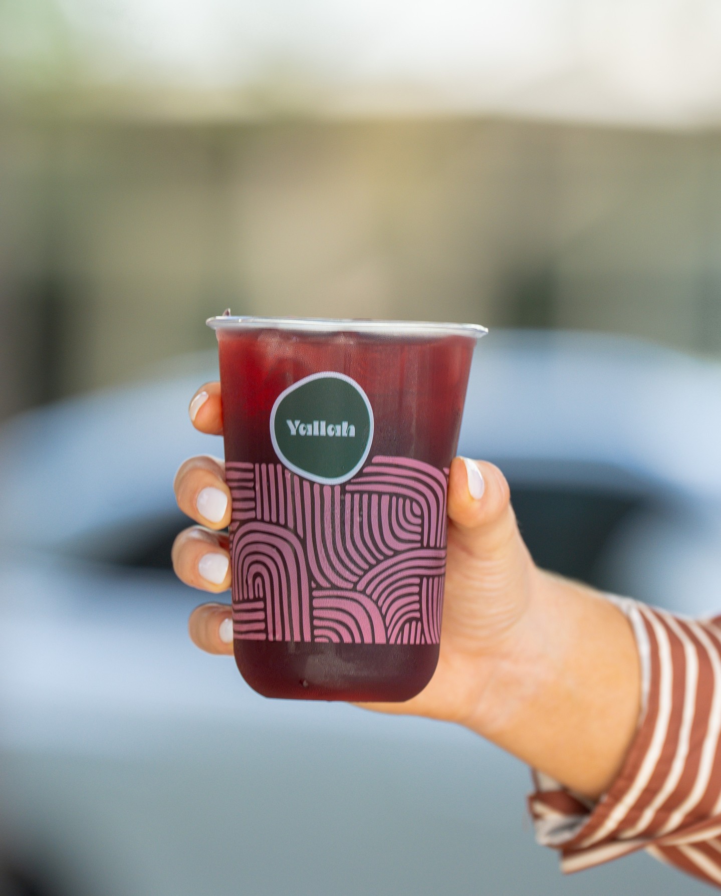 Housemade pomegranate iced tea in a Yallah cup